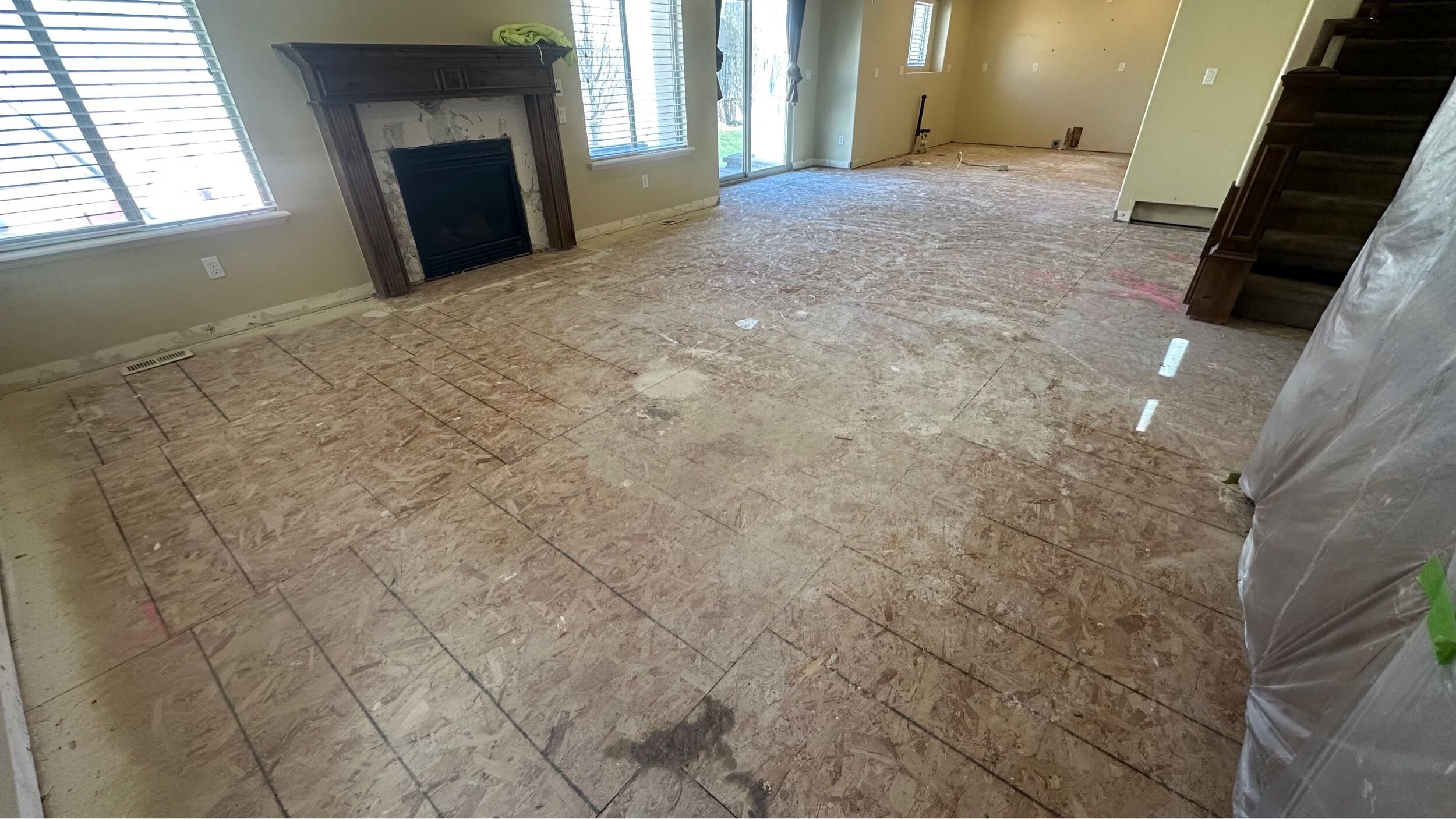 Main floor stripped to subfloor with fireplace visible — Eagle Mountain home during demo phase