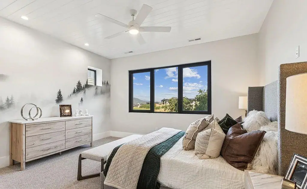Bedroom with mountain mural accent wall, shiplap ceiling, and large windows