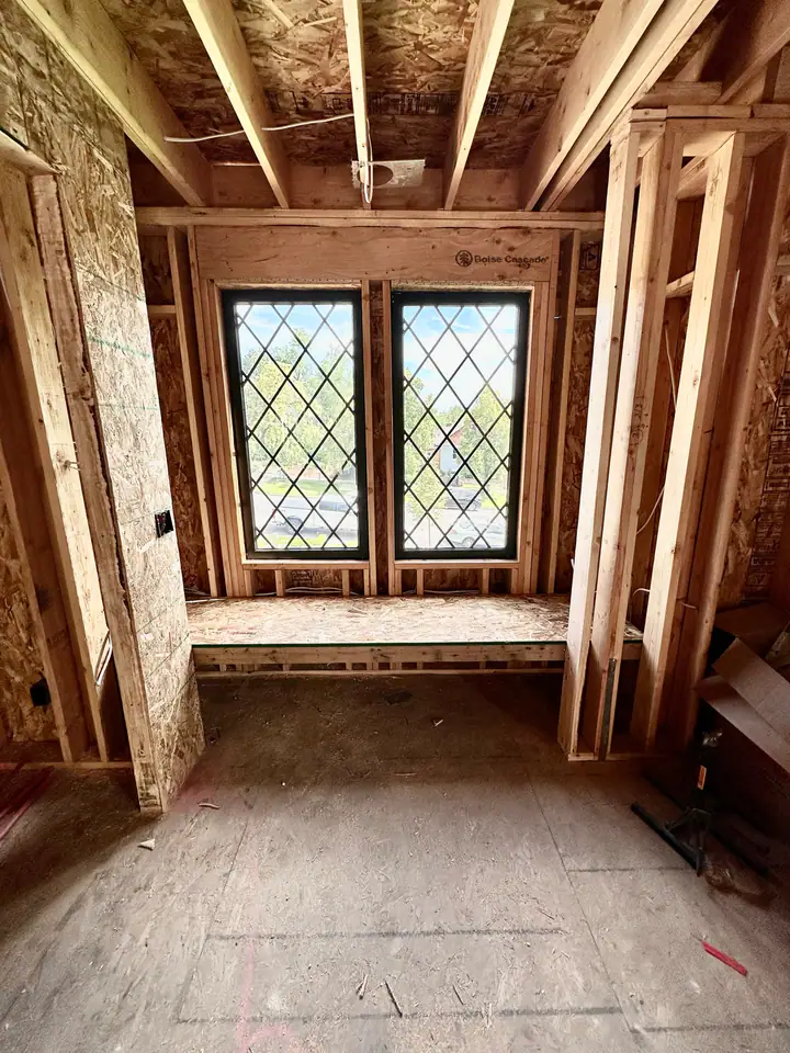 Diamond-pane leaded glass window installed in new framing with Boise Cascade LVL header, craftsmanship detail showing character-appropriate window choice