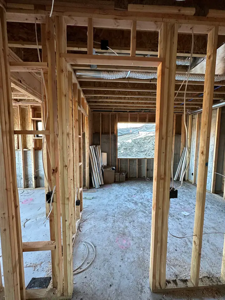 Interior framing, looking through stud walls and doorways, HVAC ductwork visible in ceiling, wiring started