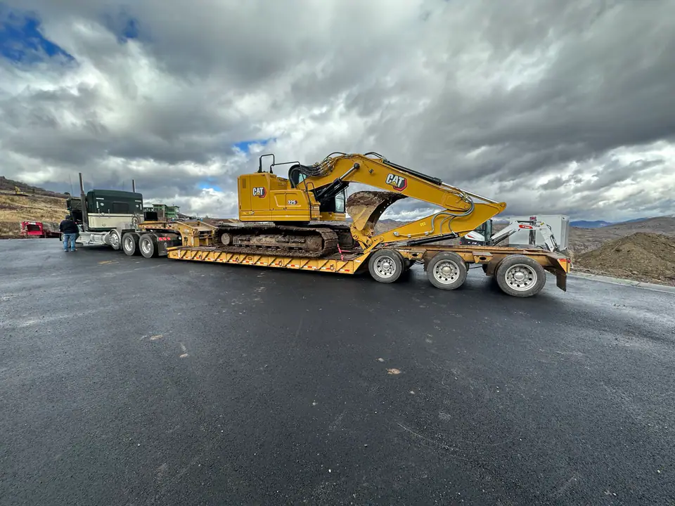 Heavy equipment arriving on flatbed trailer, Day One on the Hideout job site