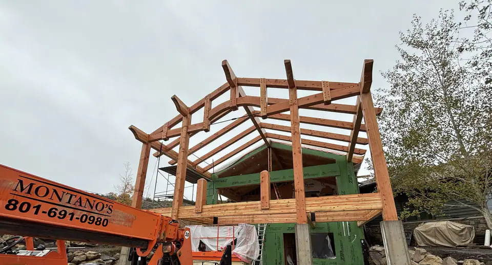 Timber-frame porch structure being set on a home addition in Tuhaye